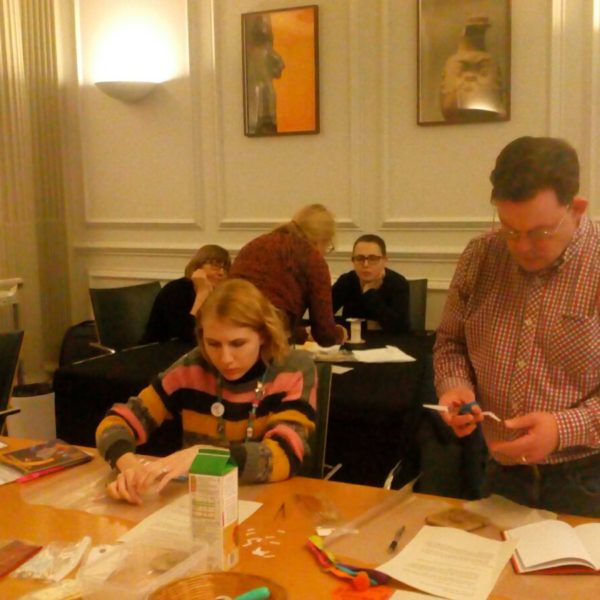 Members of NWFed at a Museums Basics event, sitting and standing around a table labelling objects.