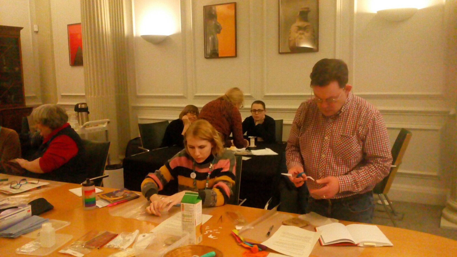 Members of NWFed at a Museums Basics event, sitting and standing around a table labelling objects.